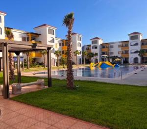 a resort with a pool with a slide and a playground at Marinamer 1 in Saïdia