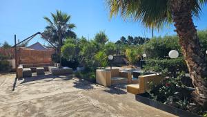 a patio with couches and a palm tree at MarEden Sicily Room , Relax e Bonsai in Favara