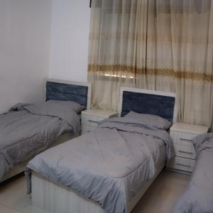 a bedroom with two twin beds and curtains at مزرعة نسيم جرش in Irbid