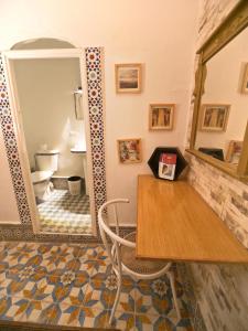 a room with a table and a bathroom with a toilet at Riad Nostalgie of Tetouan in Tétouan