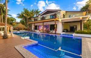 a large swimming pool in front of a house at Rainbow Holiday Resort in Nadi