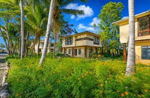 a house with palm trees in front of it at Rainbow Holiday Resort in Nadi