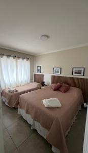 two beds in a hotel room with white curtains at Apartamento central, novo e com garagem em Curitiba in Curitiba