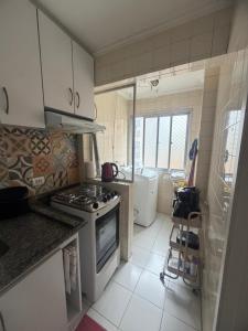 a kitchen with a stove and a sink and a tub at Apartamento central, novo e com garagem em Curitiba in Curitiba +3 photos