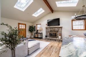 a living room with a fireplace and skylights at Modern Designed Cabin with Secluded Backyard Firepit Grill Nintendo Switch2 in Gouldsboro