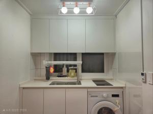 a kitchen with a sink and a washing machine at Suwon Cozy Stay in Suwŏn-yŏk