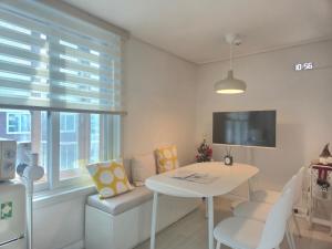 a small white room with a table and a window at Suwon Cozy Stay in Suwŏn-yŏk