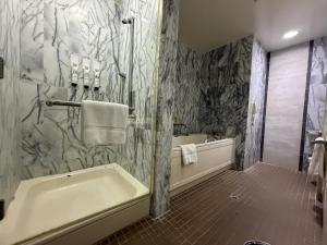 a bathroom with a bath tub and a sink at Finest Guam Golf & Resort in Yigo