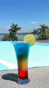 a colorful drink sitting on a table with a lemon slice at Bellagio Hills Hotel and Restaurant in Paoay
