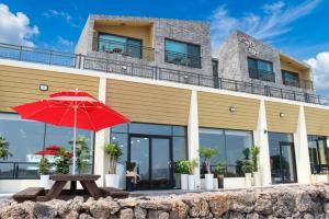 a red umbrella sitting in front of a building at Haemorat Pension in Seogwipo