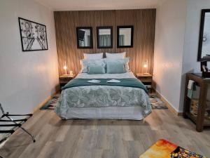 a bedroom with a large bed and two mirrors at TePopo Gardens Rural Retreat in Stratford