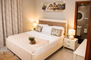 a bedroom with a white bed with a potted plant on it at Care Appartement in Kinshasa