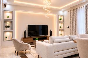 a living room with a couch and a tv at Care Appartement in Kinshasa