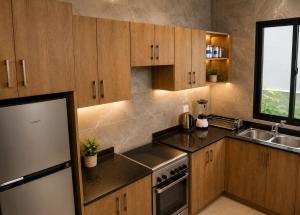 a kitchen with wooden cabinets and a sink at Care Appartement in Kinshasa +30 photos