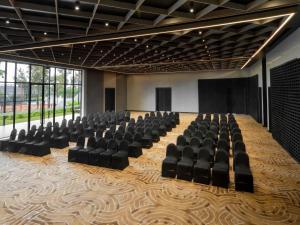 Mövenpick Kigali في كيغالي: قاعة اجتماعات بها كراسي سوداء ومنصة +71 صورة