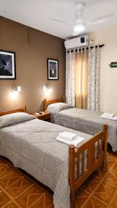 a hotel room with two beds and a window at Hospedaje Los Vencejos in Puerto Iguazú +71 photos