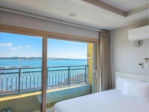 a bedroom with a view of the ocean at Haemorat Pension in Seogwipo