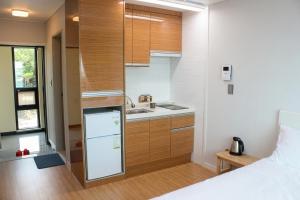 a small kitchen with a sink and a refrigerator at Haemorat Pension in Seogwipo +24 photos