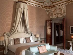 a bedroom with a large bed and a chair at Orient Express Venezia in Venice