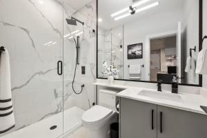 a bathroom with a shower and a toilet and a sink at The North Shore Luxe Suite in North Vancouver