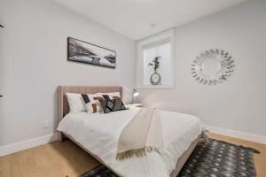 a bedroom with a bed and a mirror on the wall at The North Shore Luxe Suite in North Vancouver