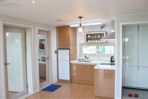 a kitchen with a sink and a refrigerator at Haemorat Pension in Seogwipo
