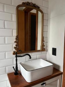 a bathroom with a white sink and a mirror at Recanto Bougainville ST in Santa Teresa +51 photos