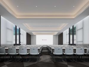 a conference room with rows of tables and white chairs at Mercure Guilin Yangshuo Xingping in Guilin +12 photos