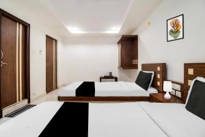 a hotel room with two beds and a window at OYO Hotel O Allipuram Near Railway Station in Visakhapatnam +37 photos