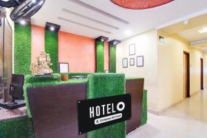 a hotel lobby with a green accent wall at OYO Hotel O Allipuram Near Railway Station in Visakhapatnam