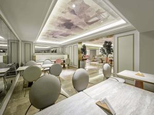 a meeting room with tables and chairs in a building at Mercure Beijing Universal Resort in Beijing