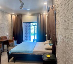 a bedroom with a bed with a blue comforter at The Doghouse in Dehradun +18 photos