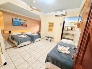 a hotel room with two beds and a room at Pousada Recifes de Corais in Porto De Galinhas +40 photos