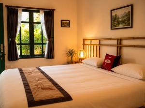 a bedroom with a large bed and a window at Tam Coc Eco House in Ninh Binh