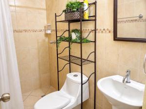 a bathroom with a toilet and a sink at Casa cómoda en zona residencial Ideal para familias y grupos in Villa Nueva