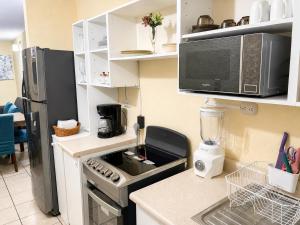 a kitchen with a stove and a microwave at Casa cómoda en zona residencial Ideal para familias y grupos in Villa Nueva +26 photos