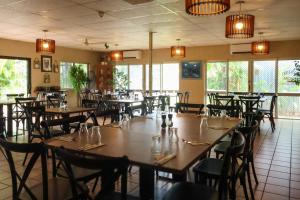a dining room with tables and chairs and windows at Wongai Beach Hotel in Horn