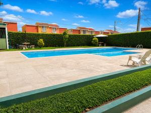 a swimming pool with a bench next to a hedge at Casa cómoda en zona residencial Ideal para familias y grupos in Villa Nueva