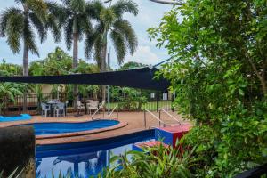 a hammock in a yard with a pool and palm trees at Wongai Beach Hotel in Horn +24 photos