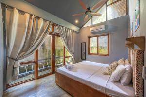 a bedroom with a large bed with windows at Union House with generator in Dapa +28 photos