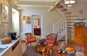 a kitchen with a table and chairs and a staircase at Hostellerie de la Motte jean in Saint-Coulomb