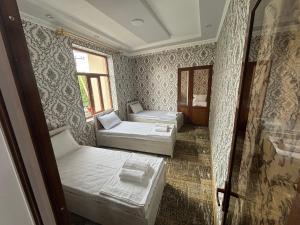 a room with two beds and a window at Geniuses in Samarkand