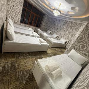 a room with four beds and a chandelier at Geniuses in Samarkand