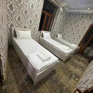 two beds sitting in a room with wallpaper at Geniuses in Samarkand +4 photos