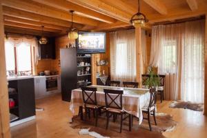 Una cocina y un comedor con mesa y sillas. en Villa Monte, en Slavske