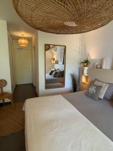 a bedroom with a large bed and a mirror at Studio Atoumo Marine 5 in Saint-François