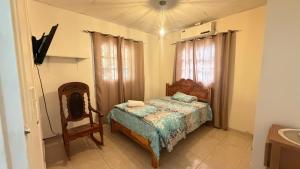 a bedroom with a bed and a chair in it at Villa azuero in Los Santos