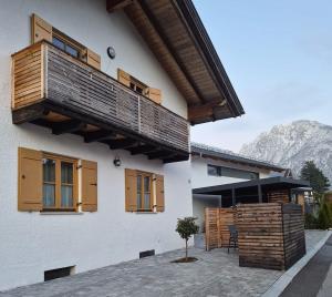 a building with a balcony and a table and chairs at Ferienwohnung Ehring in Kiefersfelden