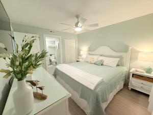 a bedroom with a bed and a vase with flowers at Beachfront Condos in Destin in Destin +106 photos