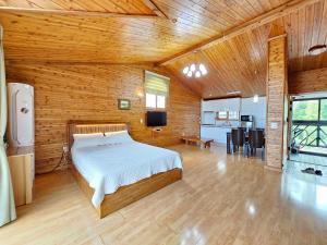 a bedroom with a bed in a room with wooden walls at Long Beach Pension in Seogwipo